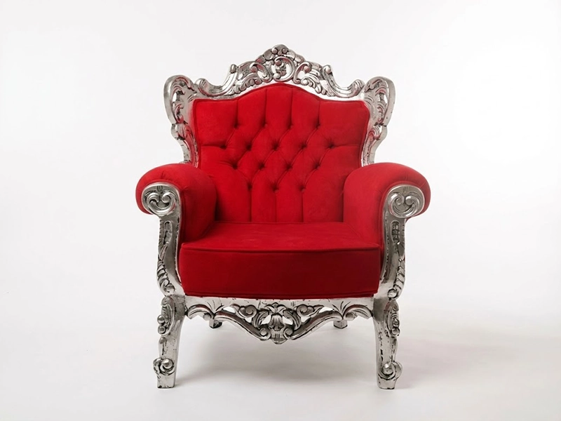 Красное велюровое кресло с высокой спинкой и светлой подушкой крупным планом