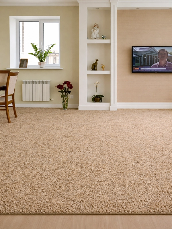 Однотонный ковер теплого песочного цвета с гладкой текстурой на светлом напольном покрытии