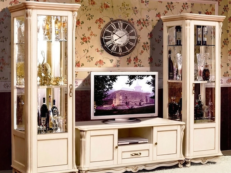 Светлый диван с красными подушками на фоне темной корпусной мебели из дерева