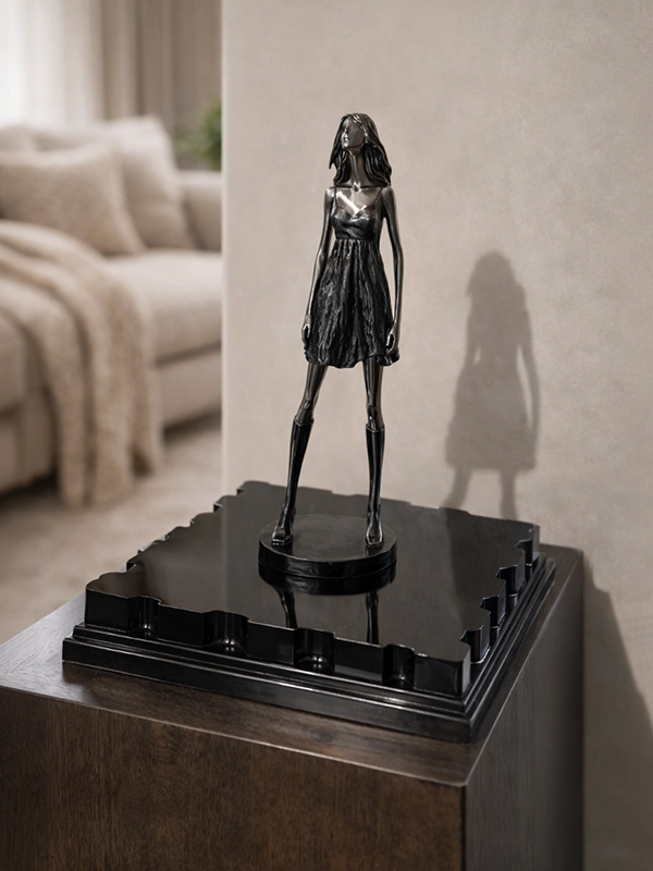 Статуэтка из черного металла в современном стиле на светлой поверхности мебели в интерьере гостиной