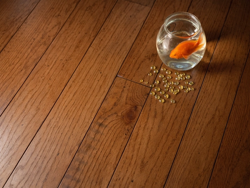 Светлая спальня в мансарде с белой кроватью, деревянным полом цвета орех и уютным текстилем в голубых тонах