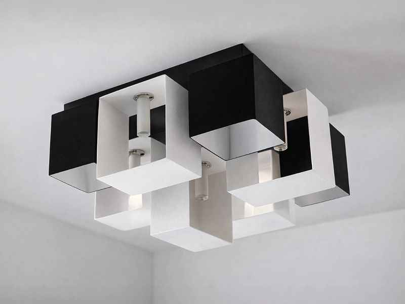 Большая черная люстра сложной формы на фоне белого потолка в интерьере гостиной с черно-белой мебелью