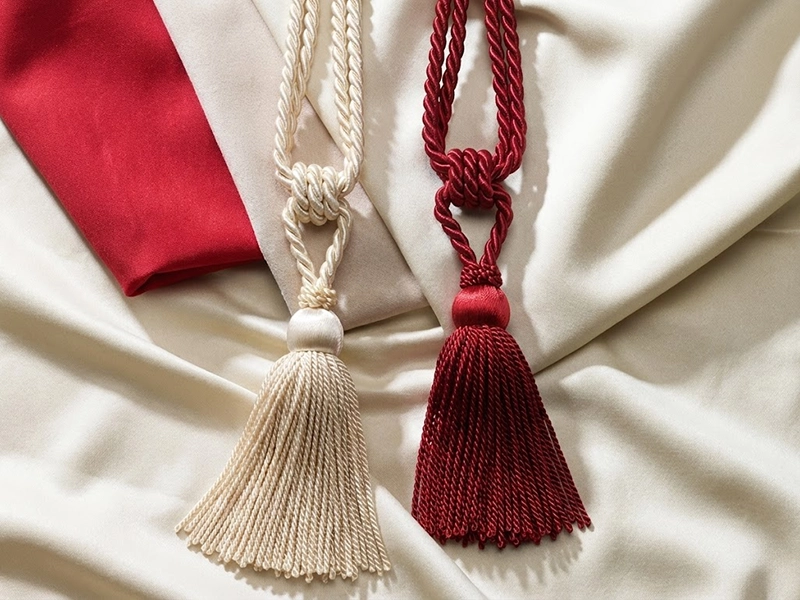 Многослойное оформление окна шторами разных оттенков красного и бежевого